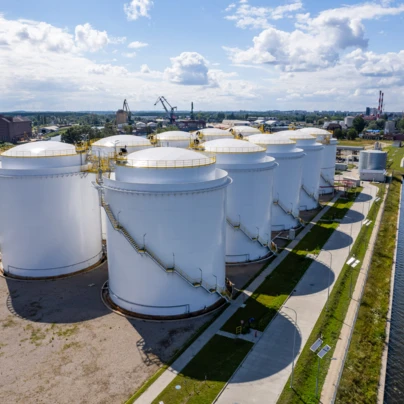 Zbiornik na przechowywanie odzwierciedlający silos fabryczny w przemysłowym otoczeniu. Przemysł spotyka się z naturą w tym uderzającym obrazie.